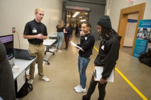 A presenter talks about his project with prospective students.