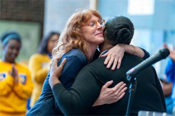  A faculty member hugs a student after a speech.