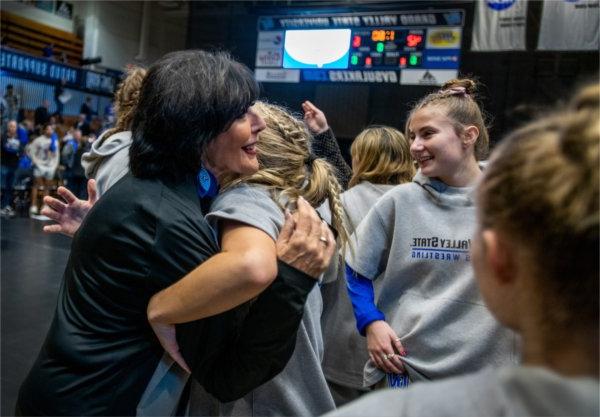 President Philomena V. Mantella hugs a wrestler following Grand Valley's dual meet against Northern Michigan.