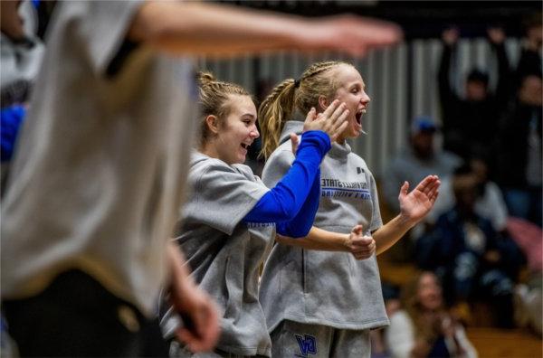 Members of the women's wrestling team cheer on a teammate during her match against Northern Michigan.