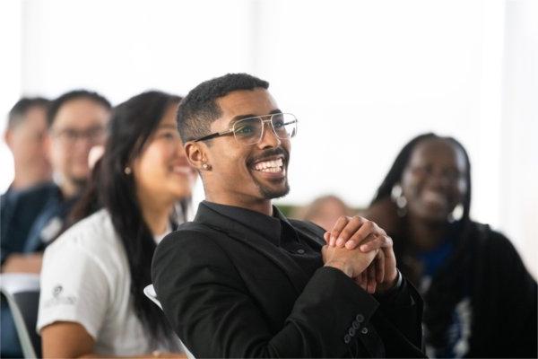 Abdul Ciise smiles and watches the national convening video.