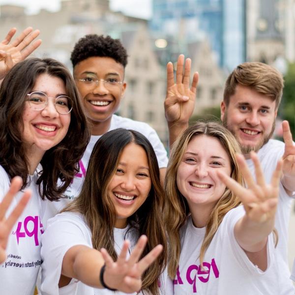 A group of REP4 mentors poses holding four fingers up.