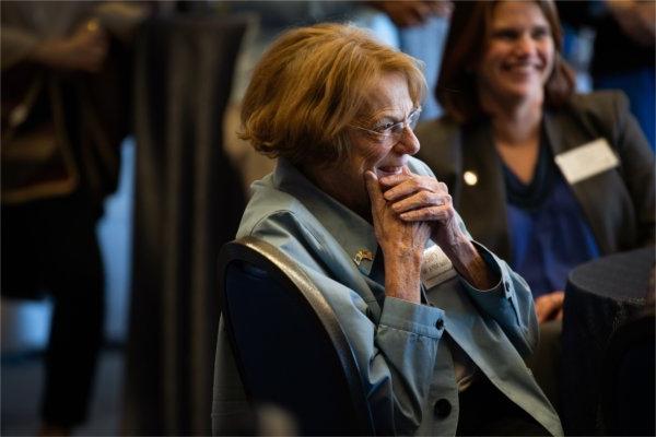  A woman holds her face in her hands while listening to remarks during an event. 