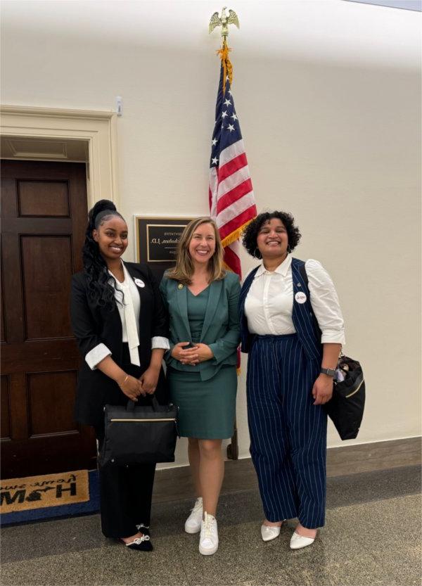 Grand Valley students Joy and Maria stand with Representative Hillary Scholten.