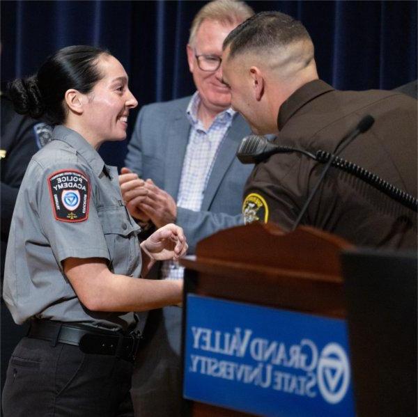 GVSU Police Academy recruit shakes hands with instructors and leadership