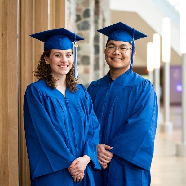 Long Ho and Grace Pallissard pose in academic regalia